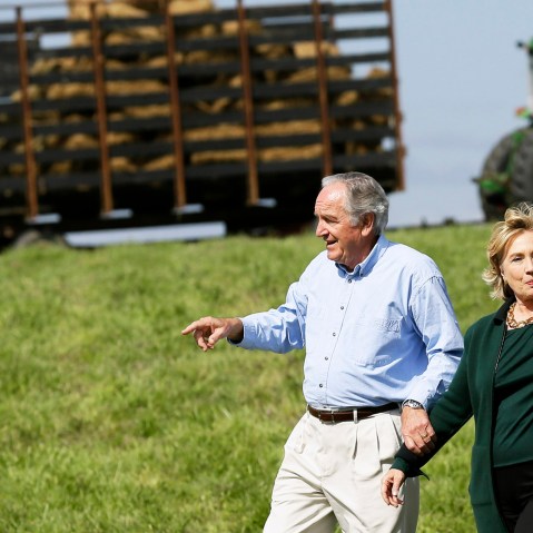 Former Secretary of State Hillary Rodham Clinton waves as she walks with U.S. Sen. Tom Harkin, left as they arrive at Harkin's annual fundraising Steak Fry, Sunday, Sept. 14, 2014, in Indianola, Iowa. (Photo by Charlie Neibergall/AP)
