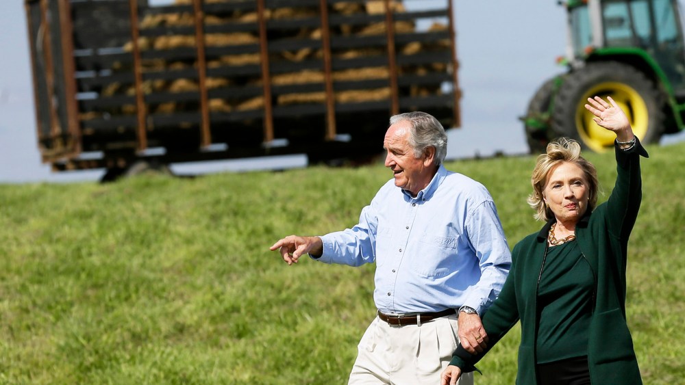 Former Secretary of State Hillary Rodham Clinton waves as she walks with U.S. Sen. Tom Harkin, left as they arrive at Harkin's annual fundraising Steak Fry, Sunday, Sept. 14, 2014, in Indianola, Iowa. (Photo by Charlie Neibergall/AP)