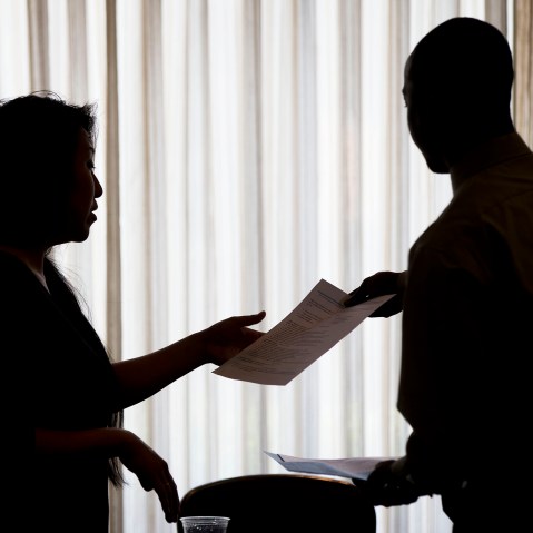In this June 23, 2014 photo a recruiter takes a resume during a job fair. (Photo by Matt Rourke/AP)