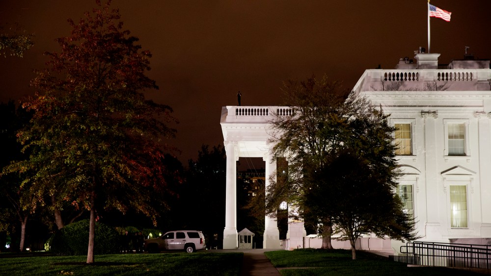 A group of Secret Service police gather on the North Lawn as a member of the Secret Service Counter Assault team surveys from the White House rooftop, Oct. 22, 2014, in Washington, D.C. (Photo by Jacquelyn Martin/AP)