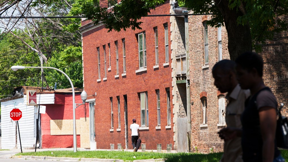 People walk through the Englewood neighborhood, on June 9, 2014 in Chicago, Illinois.