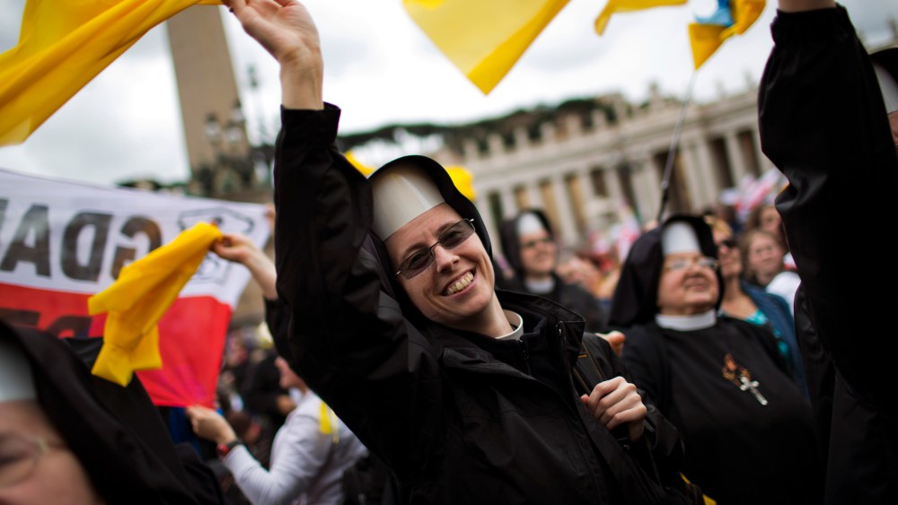 Nuns wave as Pope Francis is driven through the crowd after presiding over a solemn ceremony in St. Peter's Square at the Vatican, Sunday, April 27, 2014.