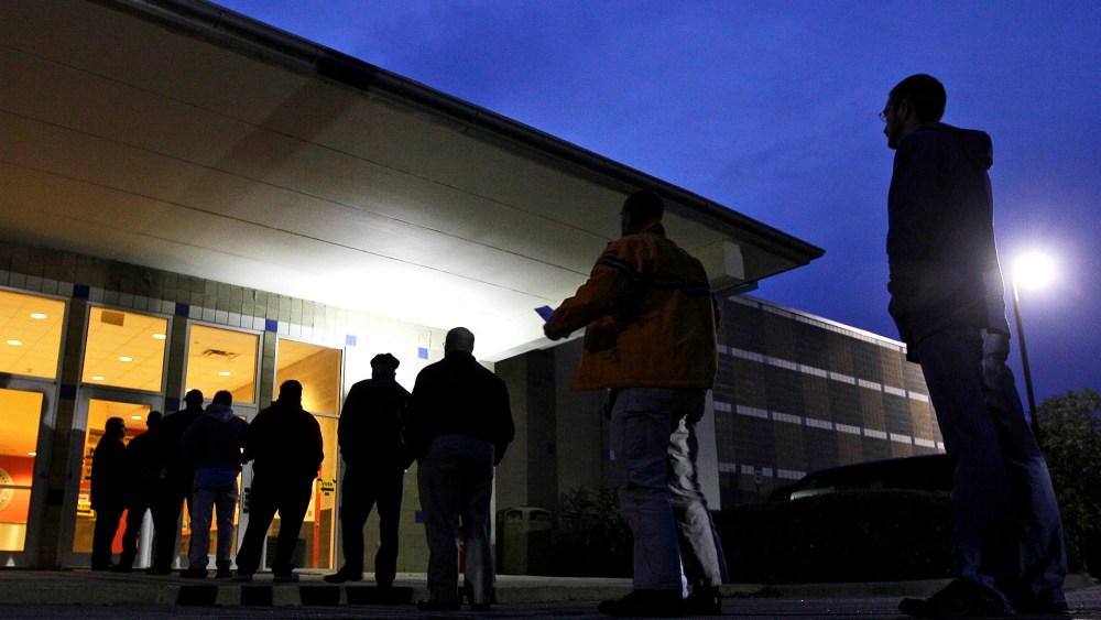 Voters stand in line before sunrise to cast their votes at a polling precinct in Apex, N.C.