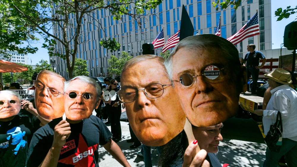 Members of the "Save Our News'' coalition protest with images of billionaire brothers Charles and Bill Koch in Los Angeles Wednesday, May 29, 2013.