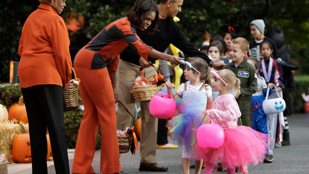 President Barack Obama, first lady Michelle Obama and her mother Marian Robinson, far left, hand out Halloween treats to 'trick-or-treaters' on the South Lawn of the White House in Washington, D.C., on Oct. 31, 2013. (Photo by Pablo Martinez Monsivais/AP)