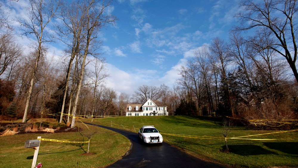 A police cruiser sits in the driveway as crime scene tape surrounds the home of Nancy Lanza, Dec. 18, 2012, in Newtown, Conn. (Photo by Jason DeCrow/AP)