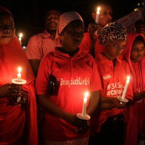 People hold candles during a vigil to mark the one year anniversary of the abduction of girls studying at the Chibok government secondary school, Abuja, Nigeria, April 14, 2015. (Photo by Sunday Alamba/AP)