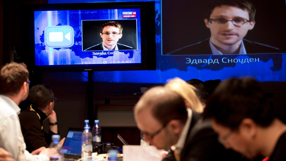 Edward Snowden, displayed on television screens, asks a question to Russian President Vladimir Putin during a nationally televised question-and-answer session, in Moscow, April 17, 2014.