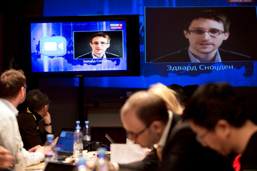 Edward Snowden, displayed on television screens, asks a question to Russian President Vladimir Putin during a nationally televised question-and-answer session, in Moscow, April 17, 2014.