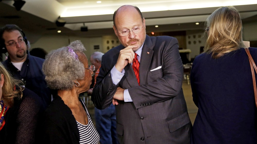 Republican mayoral hopeful Joe Lhota, center, receives instructions from a poll worker at his polling station during the primary election in New York, Tuesday, Sept. 10, 2013.