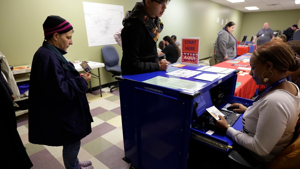 Voters stand in line to have an election official check their photo identification at an early voting polling site, in Austin, Texas on Feb. 25, 2014.