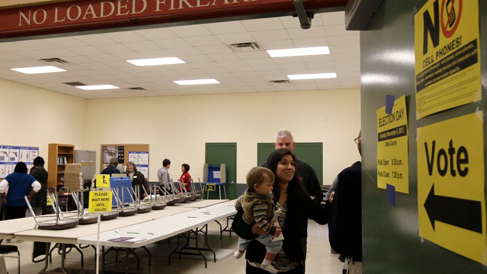 Melissa McBrien and son Tyler, 11 months, exit a polling precinct after voting at the Wake County Firearms Education and Training Center on Election Day in Apex, N.C., Tuesday, Nov. 6, 2012. (AP Photo/Gerry Broome)
