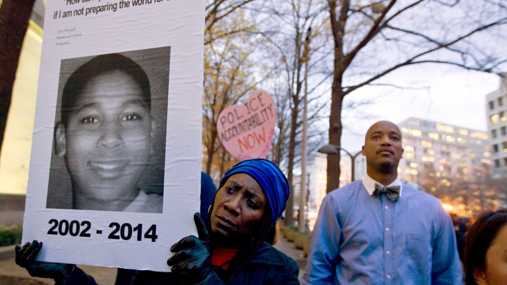 In a Monday, Dec. 1, 2014 file photo, Tomiko Shine holds up a picture of Tamir Rice, the 12 year old boy fatally shot on Nov. 22 by a rookie police officer, in Cleveland, Ohio, during a protest. (Photo by Jose Luis Magana/AP)