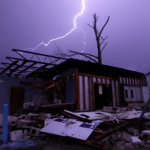 Lightning illuminates a house after a tornado touched down in Jefferson County, Ala., damaging several houses, Dec. 25, 2015, in Birmingham, Ala. A Christmastime wave of severe weather continued Friday. (Photo by Butch Dill)
