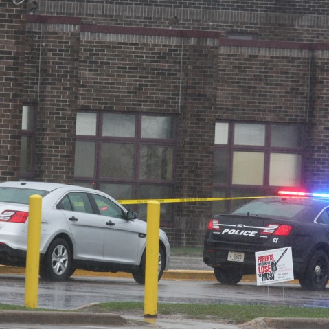 Two Antigo police department vehicles sit in front of the entrance to Antigo High School, April 24, 2016, where an 18-year-old gunman opened fire late Saturday outside of a prom at the school. (Photo by Fred Berner/Antigo Daily Journal/AP)