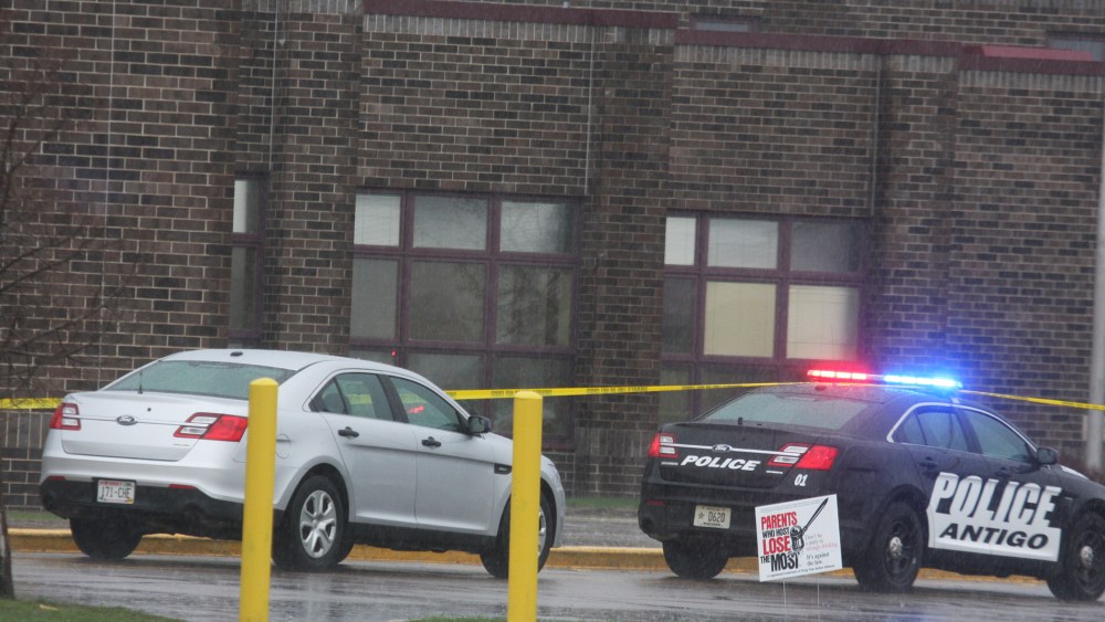 Two Antigo police department vehicles sit in front of the entrance to Antigo High School, April 24, 2016, where an 18-year-old gunman opened fire late Saturday outside of a prom at the school. (Photo by Fred Berner/Antigo Daily Journal/AP)