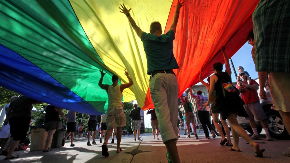 Supporters of a U.S. Supreme Court ruling which overturns the federal Defense of Marriage Act (DOMA) carry a large rainbow flag during a parade around the Wisconsin State Capitol in Madison, Wis. Wednesday, June 26, 2013.