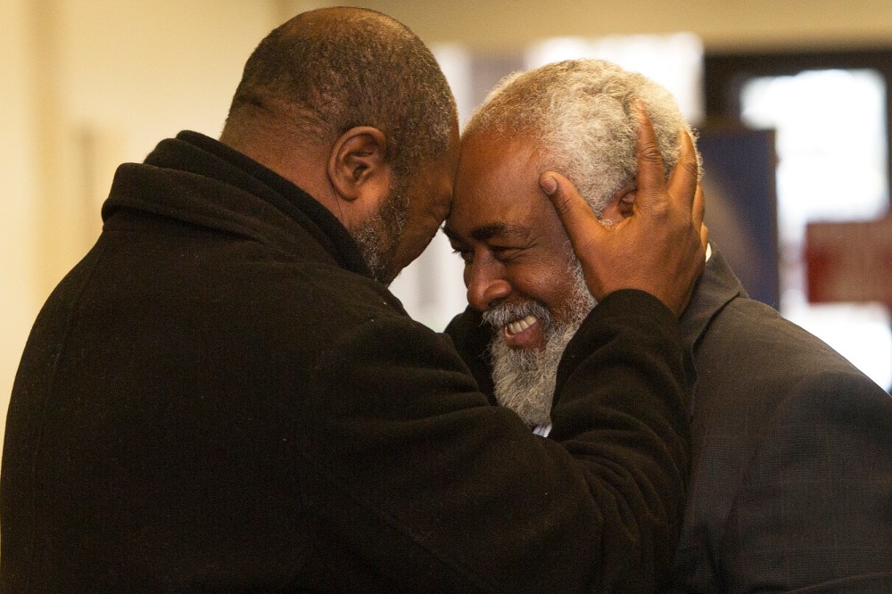 Wiley Bridgeman 60, right, of Cleveland, is greeted by his brother Ronnie, who is now known as Kwame Ajamu, after his release from a life sentence an hour earlier, by Cuyahoga County Common Pleas Judge David Matia, Nov. 21, 2014, in Cleveland.