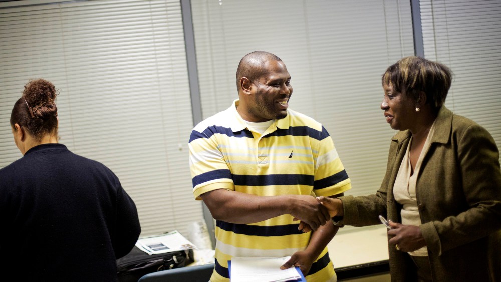 Reginald Wright, center, Vivian Moore, right, who helped with his online application for health insurance, on March 31, 2014, in Atlanta, Ga.