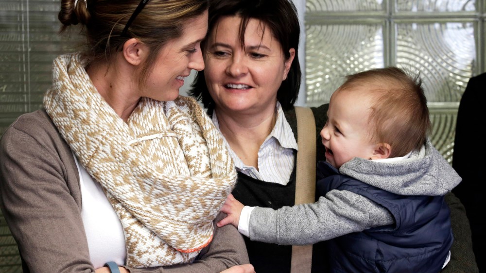 Amanda Broughton, left, looks at one of her twin sons being held by her partner Michele Hobbs, on Feb. 10, 2014, during a news conference in Cincinnati.