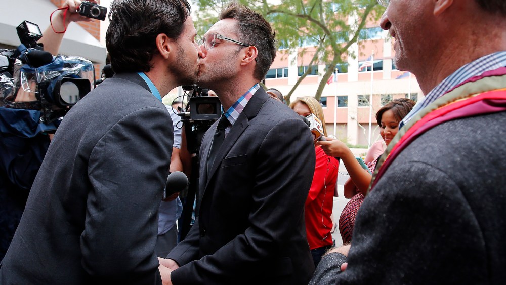 Kevin Patterson, left, and David Larance kiss after exchanging vows, as Rev. John Dorhaer, who performed the ceremony, stands at right, Oct. 17, 2014, in Phoenix, Ariz. (Photo by Rick Scuteri/AP)