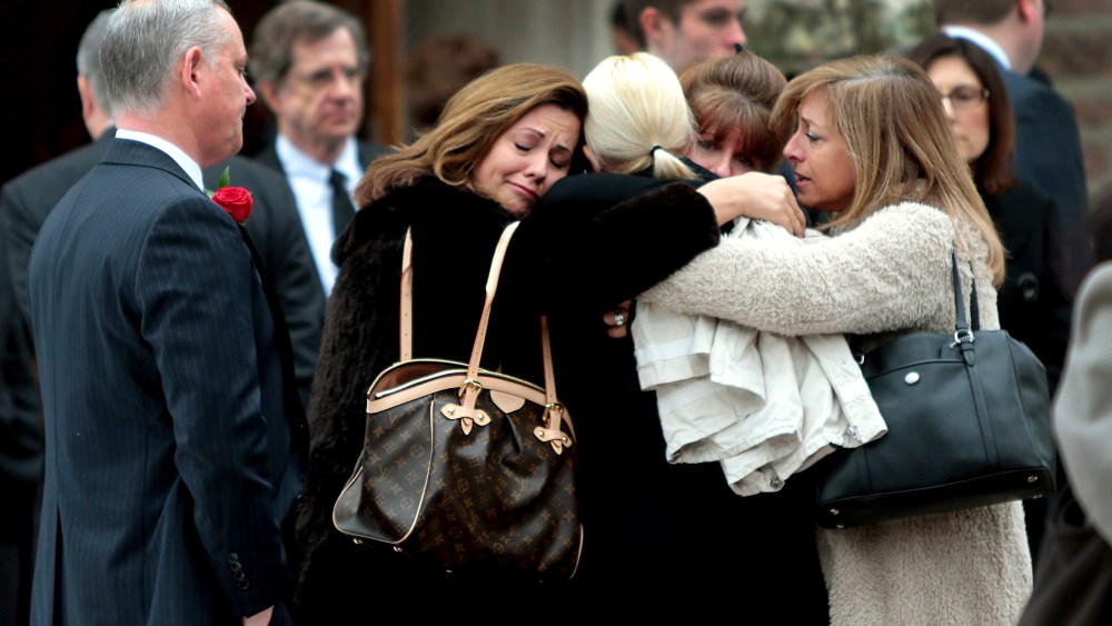 Family members of Missouri State Auditor Tom Schweich embrace outside The Church of St. Michael and St. George in Clayton, Mo., after his funeral on March 3, 2015. (Photo by Robert Cohen/St. Louis Post-Dispatch via AP)