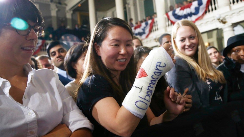 Cathey Park, from Cambridge, Mass., shows the words "I Love Obamacare" on her cast for her broken wrist as she waits for President Barack Obama to speak about the federal health care law, Oct. 30, 2013 in Boston.