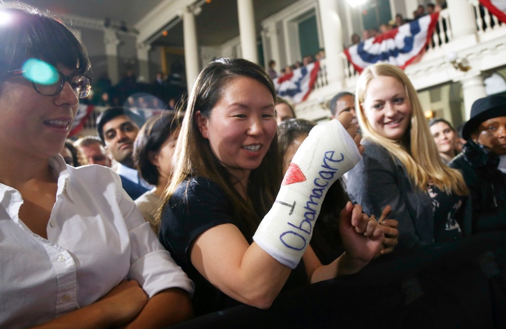 Cathey Park, from Cambridge, Mass., shows the words "I Love Obamacare" on her cast for her broken wrist as she waits for President Barack Obama to speak about the federal health care law, Oct. 30, 2013 in Boston.