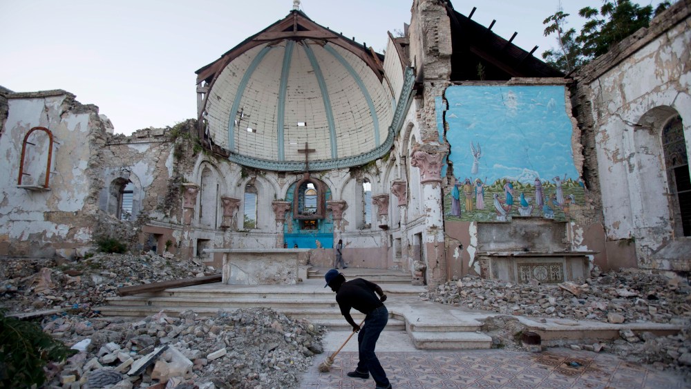 A man sweeps an exposed tiled area of the earthquake-damaged Santa Ana Catholic church, where he now lives, in Port-au-Prince, Haiti, Saturday, Jan. 12, 2013. Haitians recalled Saturday the tens of thousands of people who lost their lives in the...