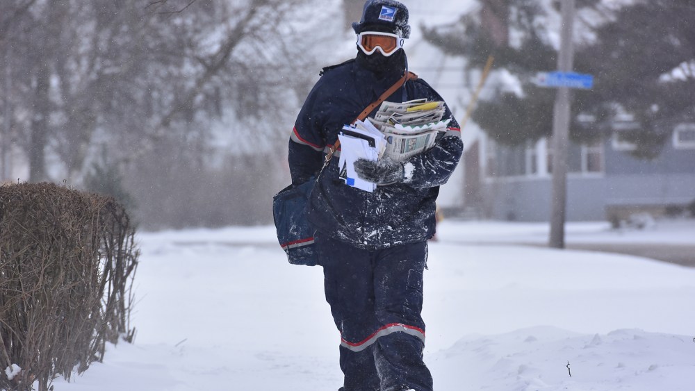 Jake Cote, a carrier with the United States Postal Service, delivers mail along Sunset Avenue, Feb. 11, 2016, in Utica, N.Y. (Photo by Mark DiOrio/Observer-Dispatch/AP)