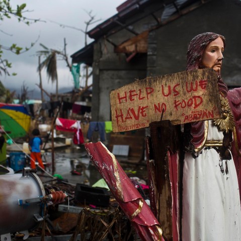 A plea for help painted on a sign hangs from a damaged statue of Jesus in a Typhoon Haiyan destroyed neighborhood in Tacloban, Philippines on Nov. 22, 2013.