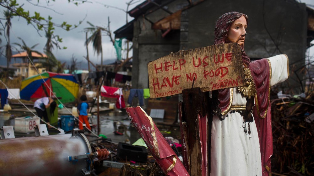 A plea for help painted on a sign hangs from a damaged statue of Jesus in a Typhoon Haiyan destroyed neighborhood in Tacloban, Philippines on Nov. 22, 2013.
