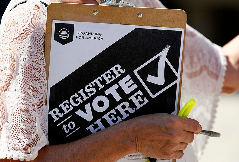 Campaign volunteer Barbara Smalley-McMahan clutches her pad while attempting to register voters in downtown Raleigh, N.C., on Sept. 26, 2012. (Gerry Broome/AP)