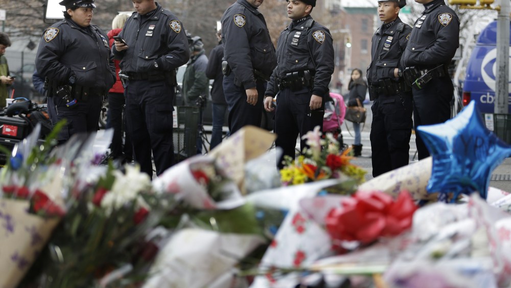 New York City police officers gather near a makeshift memorial near the site where fellow officers Rafael Ramos and Wenjian Liu were murdered in the Brooklyn borough of New York, Dec. 22, 2014.