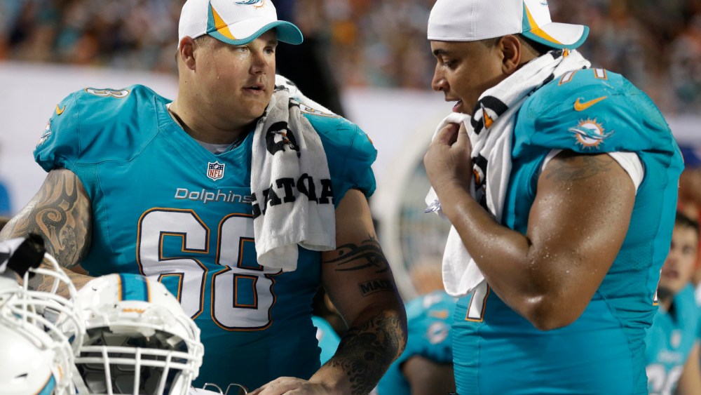 Miami Dolphins guard Richie Incognito (68) and tackle Jonathan Martin (71) looks over plays during the second half of an NFL preseason football game against the Tampa Bay Buccaneers, Saturday, Aug. 24, 2013 in Miami Gardens, Fla.