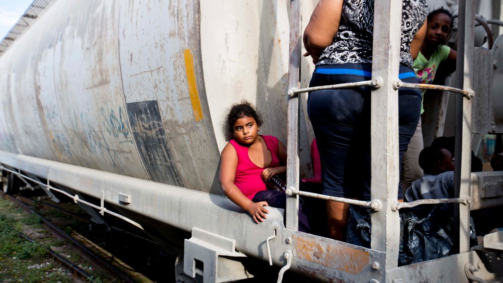 A young migrant girl waits for a freight train to depart on her way to the U.S. border, in Ixtepec, Mexico, July 12, 2014.