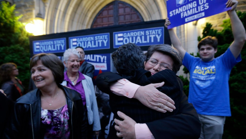 Cindy Meneghin, second from right, hugs her attorney Hayley Gorenberg during a rally at Garden State Equality in Montclair, N.J., after a Superior Court Judge ruled that New Jersey is unconstitutionally denying federal benefits to gay couples and must all