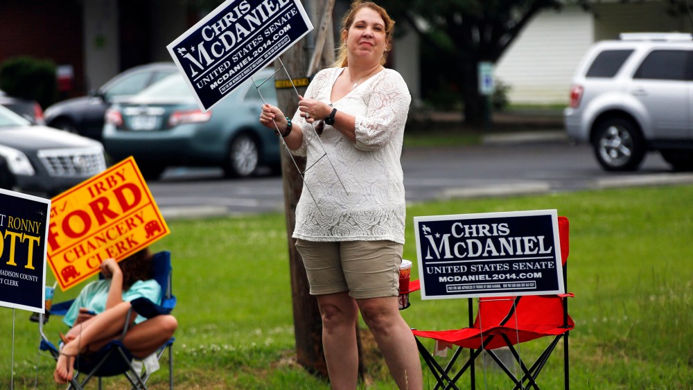 A woman waves her campaign sign for state Sen. Chris McDaniel, who is running against incumbent U.S. Sen. Thad Cochran in the GOP primary, June 3, 2014, in Madison, Miss.