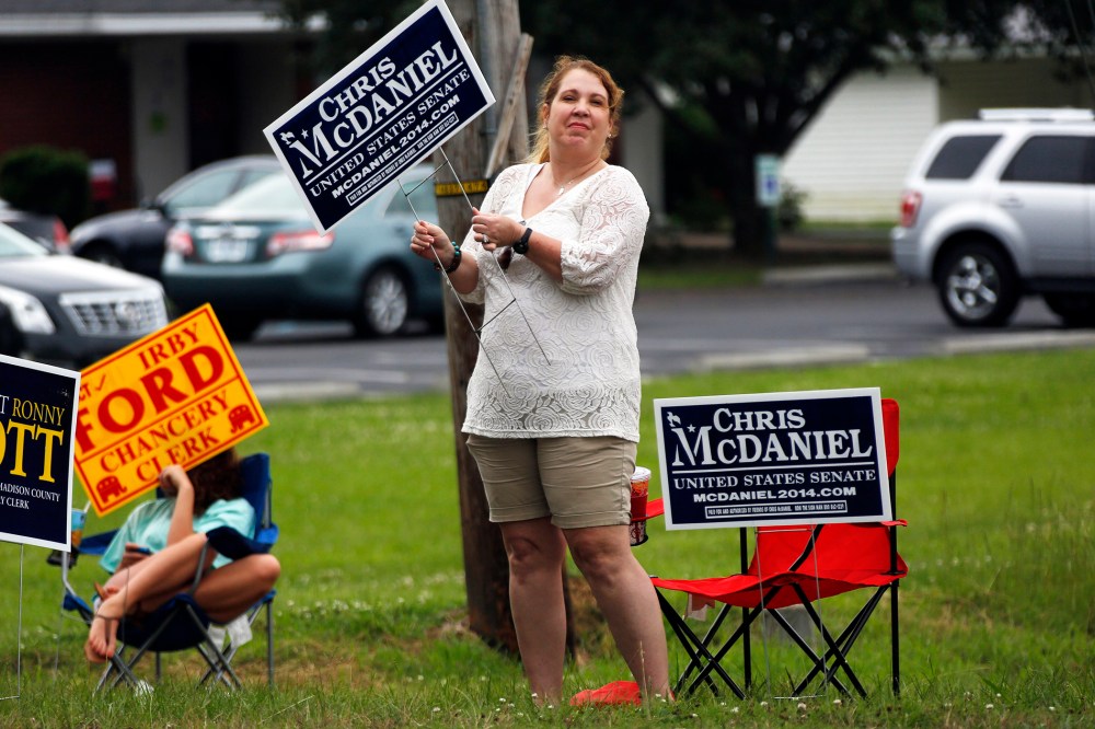 A woman waves her campaign sign for state Sen. Chris McDaniel, who is running against incumbent U.S. Sen. Thad Cochran in the GOP primary, June 3, 2014, in Madison, Miss.
