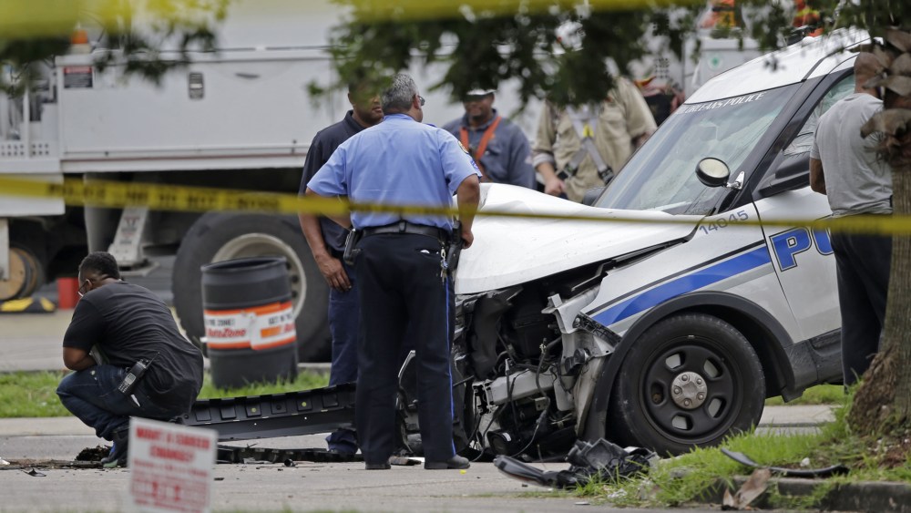 Investigators look over a New Orleans Police department vehicle in which one officer was shot and killed while transporting a prisoner in New Orleans, La. on June 20, 2015. (Photo by Gerald Herbert/AP)