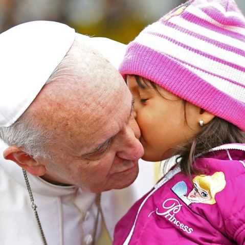Pope Francis kisses a child as he arrives in his popemobile to the Aparecida basilica in Aparecida, Brazil, Wednesday, July 24, 2013. (Photo by Victor R. Caivano/AP)