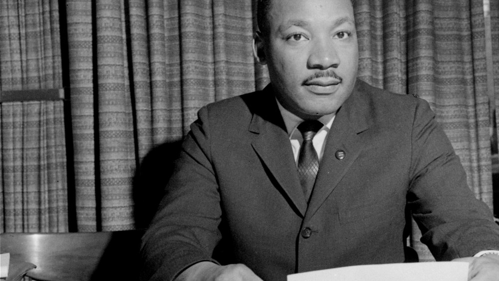 Dr. Martin Luther King, Jr. is shown discussing a forthcoming speech, March 18, 1964, from his home in Atlanta, Ga. (Photo by AP)