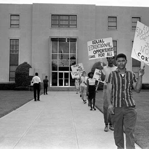 Members of CORE march in front of the administration building of the Dallas Independent School District carrying placards in Dallas, Texas on Aug. 26, 1964.