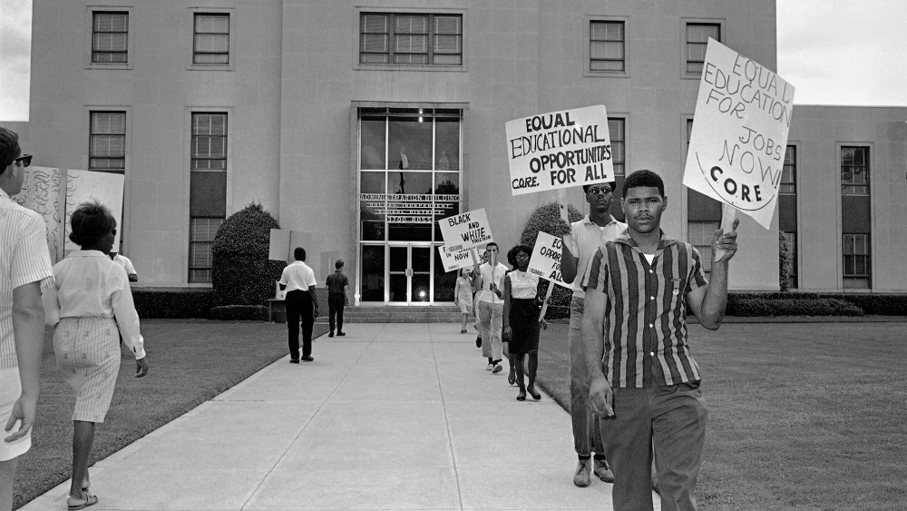 Members of CORE march in front of the administration building of the Dallas Independent School District carrying placards in Dallas, Texas on Aug. 26, 1964.