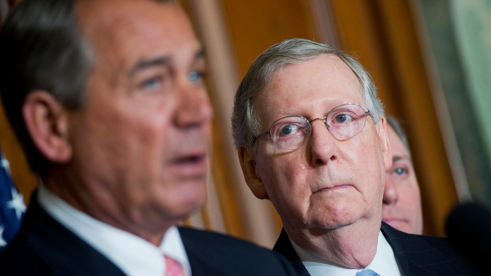 Senate Majority Leader Mitch McConnell looks on as Speaker John Boehner makes remarks during a signing ceremony in the Capitol's Rayburn Room for a bipartisan Medicare bill, April 16, 2015. (Photo By Tom Williams/CQ Roll Call/AP)