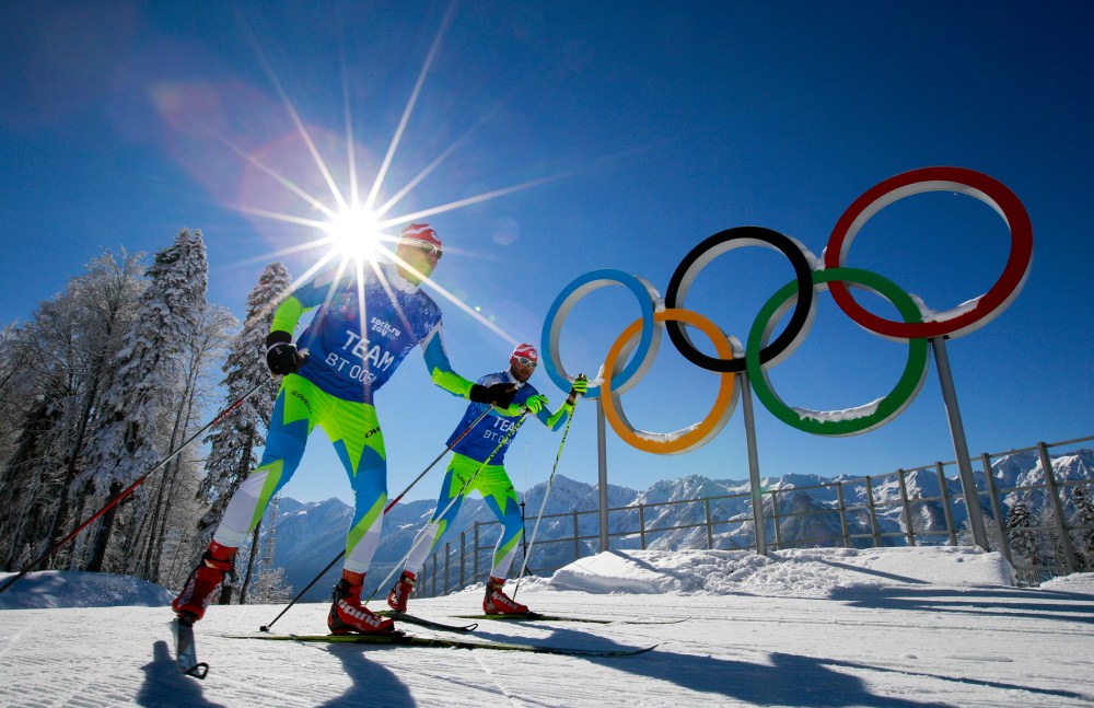Members of the Slovenian Cross-country ski team ski in front of Olympic rings at Laura Cross-country Ski & Biathlon Center of the 2014 Winter Olympics, Feb. 2, 2014, in Krasnaya Polyana, Russia.