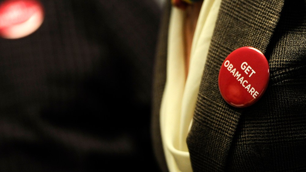 Associates at Community Health Center wear buttons reading "Get Obamacare" during a session to enroll people in the nation's new health insurance system at the Community Health Center, Tuesday, Oct. 1, 2013, in New Britain, Conn.