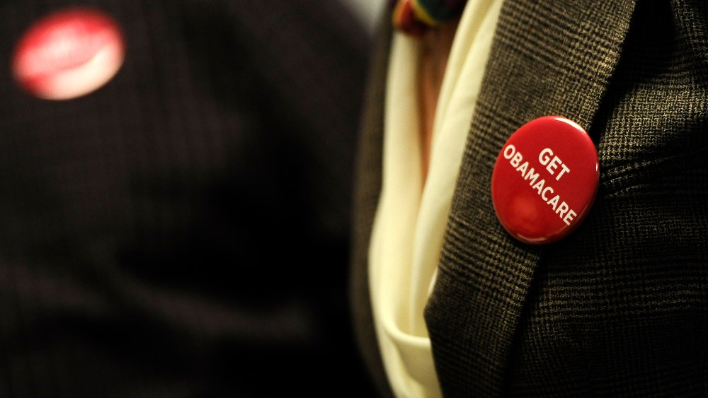 Associates at Community Health Center wear buttons during a session to enroll people in the nation's new health insurance system Oct. 1, 2013, in New Britain, Conn.