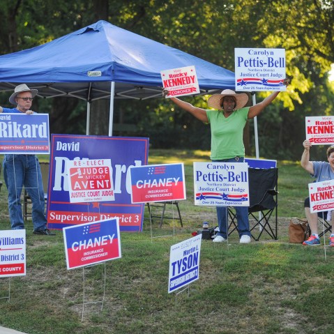 Monte Ochs, Litisha Liggins and Trish Cousley hold campaign signs outside the polls at the Stone Recreation Center in Oxford, Miss., on Aug. 4, 2015, for the primary election for county and state offices. (Photo by Bruce Newman/Oxford Eagle/AP)