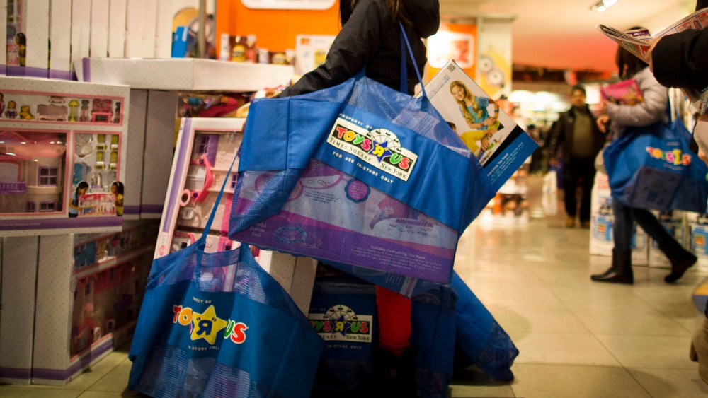 A shopper waits with her bags in the Times Square Toys R' Us on Nov. 28, 2013, Thanksgiving Day, in New York.